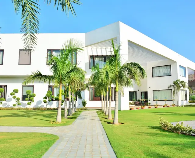 Completed lawn and palm landscape at a white building
